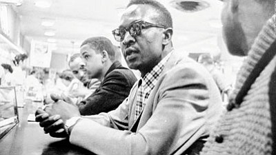 While a student at A&T State University, Muldrow participated in one of the first student lunch counter sit-ins at a Woolworth store in Greensboro, North Carolina to protest segregation.