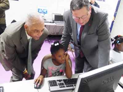 Dr. Gregory Thornton, CEO of Baltimore City Public Schools (left) and David L. Cohen, Senior Executive Vice President of Comcast Corporation (right) observes a student using the Internet at Towanda Community Center. 