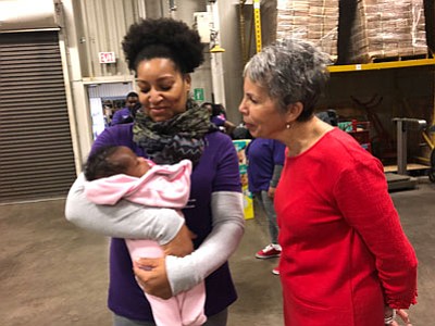 Bronwyn Mayden MSW, assistant dean at the University of Maryland School of Social Work admiring an infant.