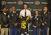 (Left to right) United States Army Representatives Sergeant First Class McConnell; Sergeant First Class McGaskey; and Second Lieutenant Brown at the presentation of a team jersey to Calvert Hall College High School student Lawrence Cager, a standout wide receiver who was selected to play in the 2015 U.S. Army All-American Bowl.                      