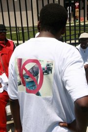 Bell shows the back of his shirt, which urges men to say no to sagging pants