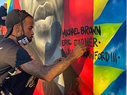 Comacell Brown paint a mural of George Floyd and others who have lost their lives to police brutality. The mural is located in Susan Campbell Park in downtown Annapolis.