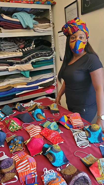 Jillian Soluade stands by face masks sewn by her husband, Abiodun Soluade. She is wearing one of their company’s stylist creations. Jillian has been actively encouraging others to wear face masks, through her social media presence.