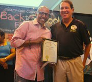 (Right) Kevin Liles received a plaque from Baltimore County Executive Kevin Kamenetz at the “Kevin Liles for a Better Baltimore Foundation” back to school event last year. The back to school festival this year will be held on Saturday, August 24, 2013 at Security Square Mall from noon to 4 p.m.                       