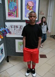 Malique stands beside his drawing entitled “Fire.”
