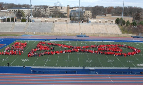 Students, activists create living red ribbon in commemoration of World AIDS Day